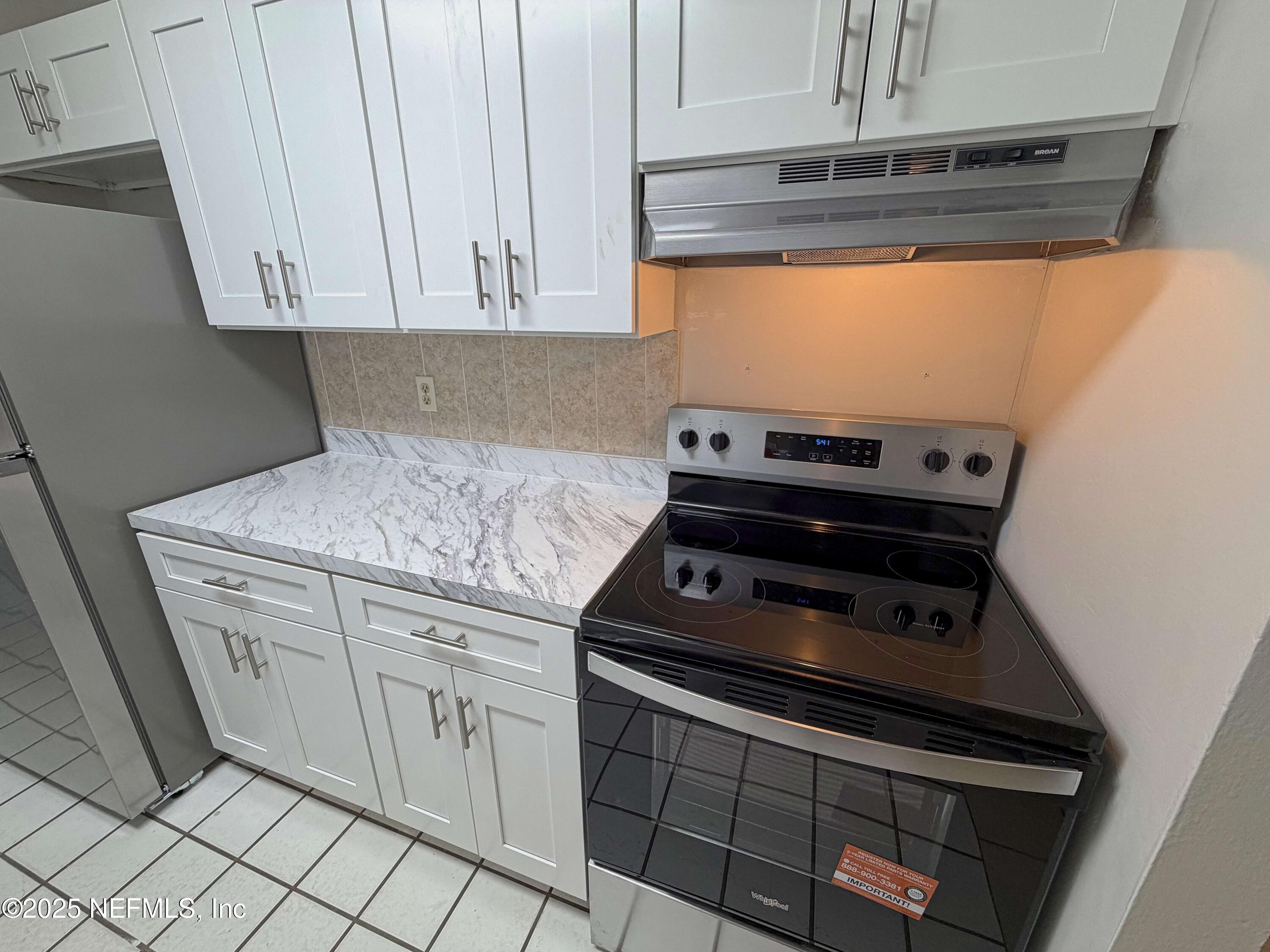 283 Almansa Road St. Augustine, FL 32086 - Photo 7 of 16 a kitchen with a stove and a microwave