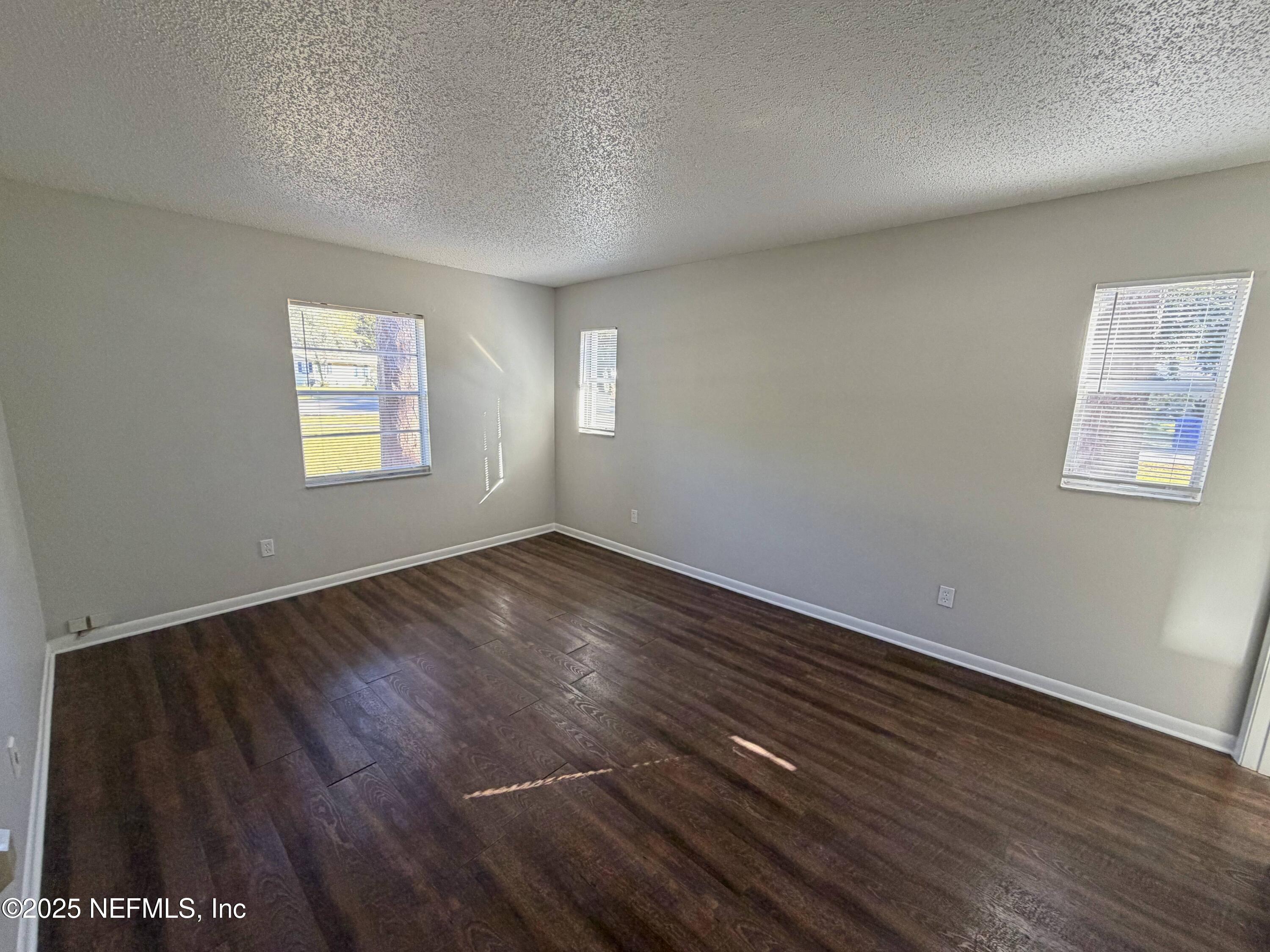 283 Almansa Road St. Augustine, FL 32086 - Photo 9 of 16 an empty room with wooden floor and windows