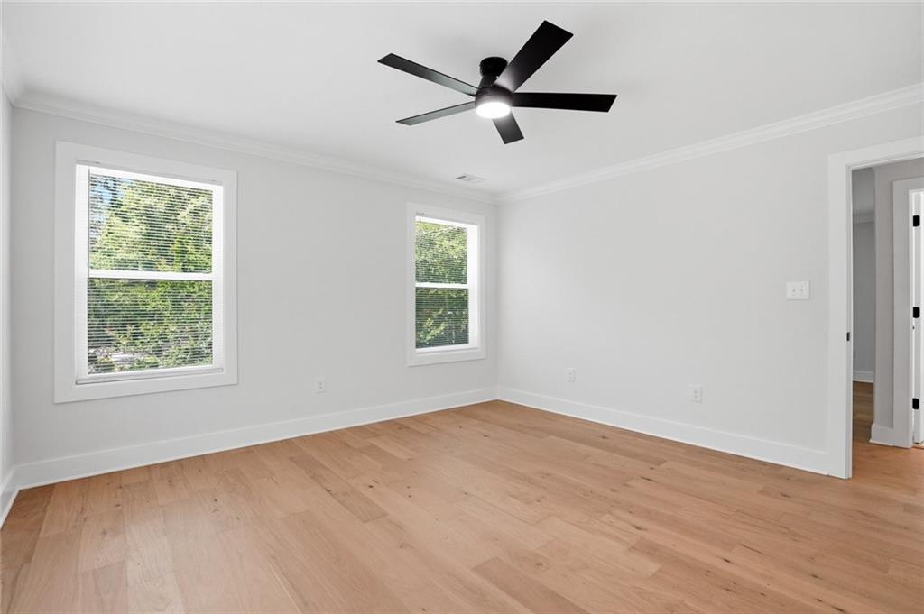 134 Henry Meyer Road Winterville, GA 30683 - Photo 19 of 34 an empty room with wooden floor ceiling fan and windows