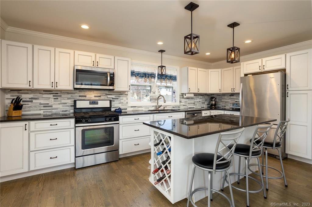 High-end kitchen with granite countertops, soft close cabinets, stainless steel appliances and gleaming hardwood floors