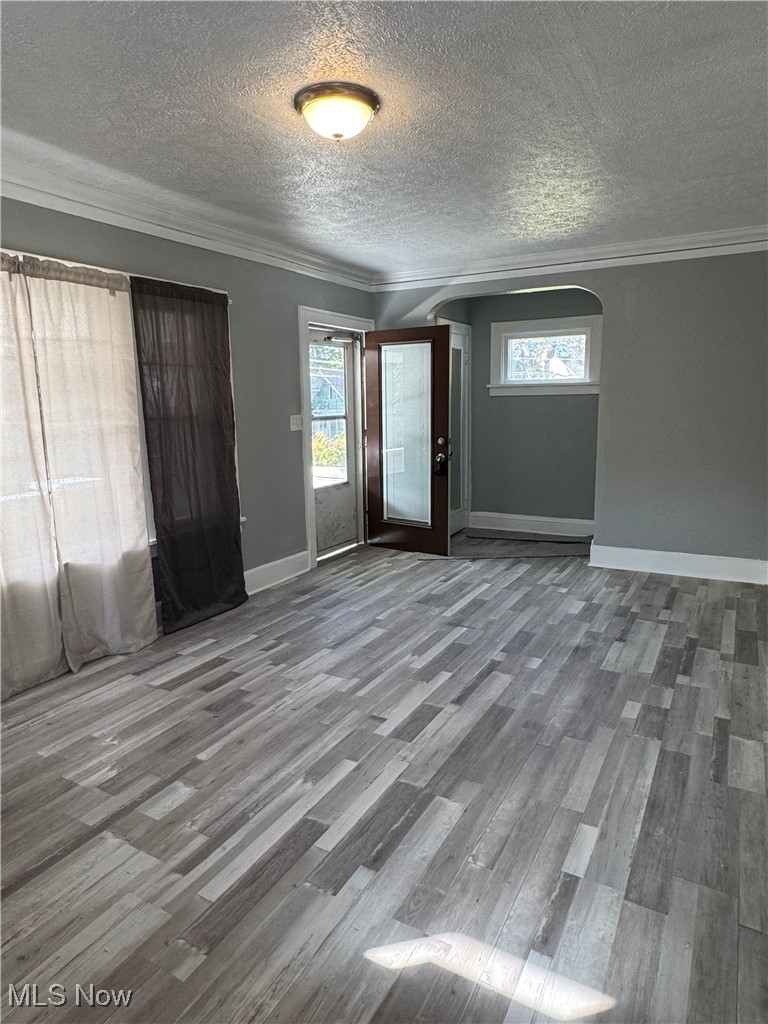 2121 Alton Road Cleveland, OH 44112 - Photo 13 of 44 Foyer featuring crown molding, wood finished floors, arched walkways, and a textured ceiling