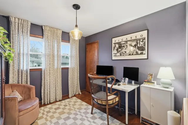 a view of a workspace with furniture and a window