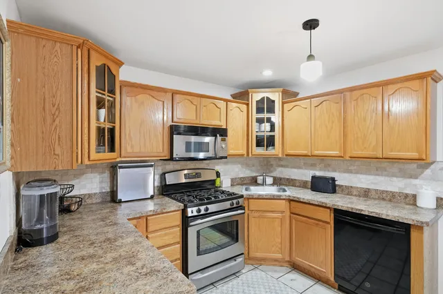a kitchen with stainless steel appliances granite countertop a stove sink microwave and cabinets