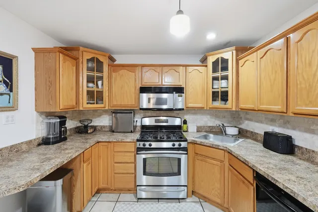 a kitchen with stainless steel appliances granite countertop a stove sink and cabinets