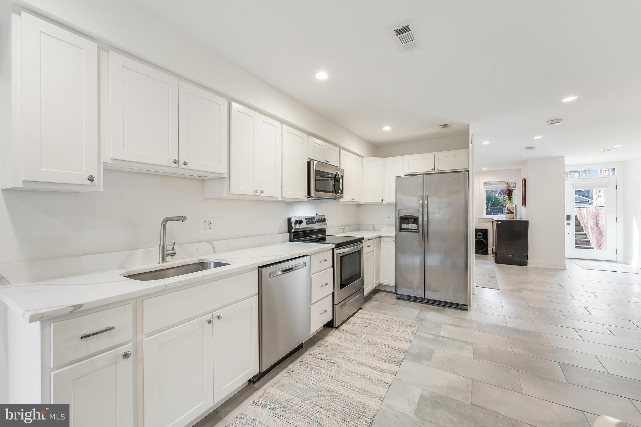 648 F Street Northeast Washington, DC 20002 - Photo 32 of 45 a kitchen with white cabinets and stainless steel appliances