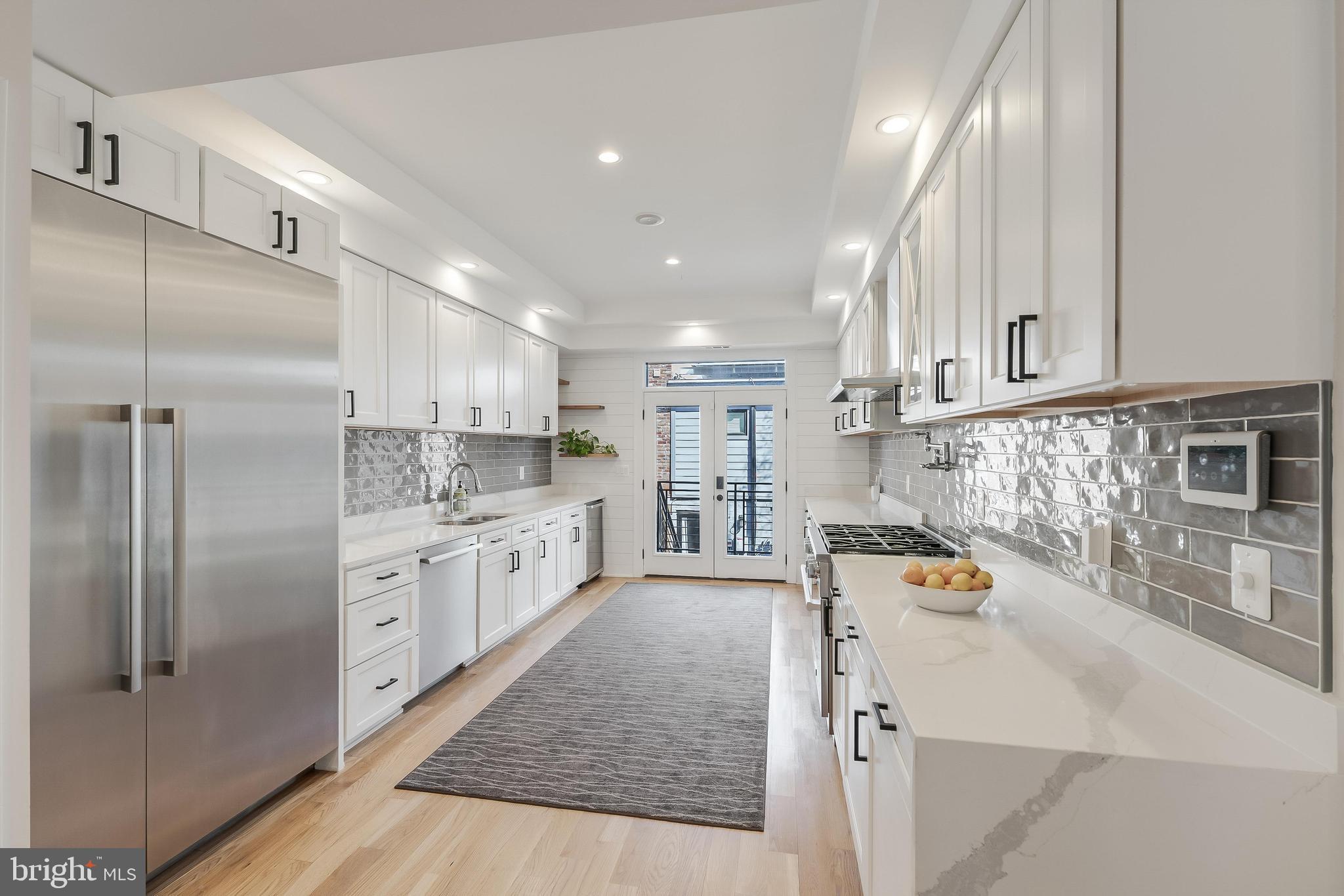 648 F Street Northeast Washington, DC 20002 - Photo 7 of 45 a large kitchen with stainless steel appliances kitchen island granite countertop a refrigerator and a sink