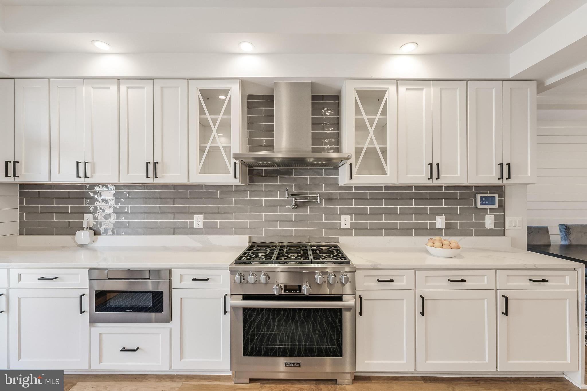 648 F Street Northeast Washington, DC 20002 - Photo 8 of 45 a kitchen with stainless steel appliances granite countertop a stove and white cabinets