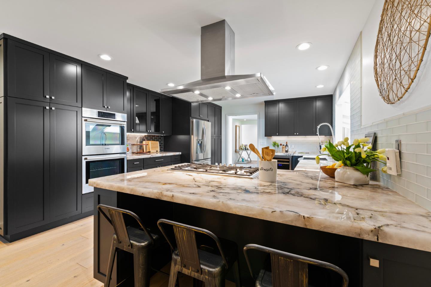 721 Occidental Avenue San Mateo, CA 94402 - Photo 21 of 60 a kitchen with stainless steel appliances kitchen island granite countertop a table chairs in it and wooden floors