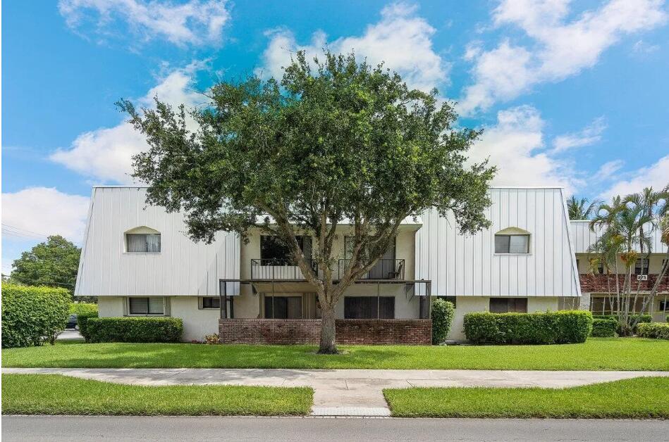 875 Northwest 13th Street, Unit 405 Boca Raton, FL 33486 - Photo 1 of 16 a front view of a house with a garden