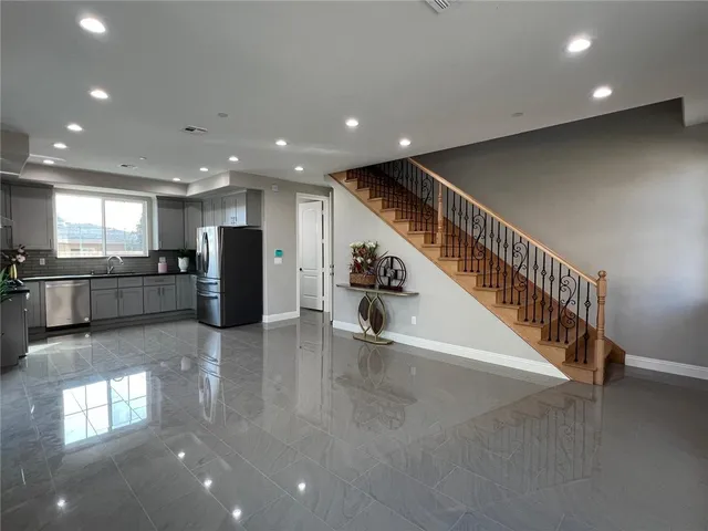 a view of kitchen with stainless steel appliances wooden floor and windows