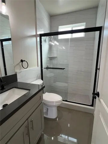 a bathroom with a granite countertop sink toilet and shower