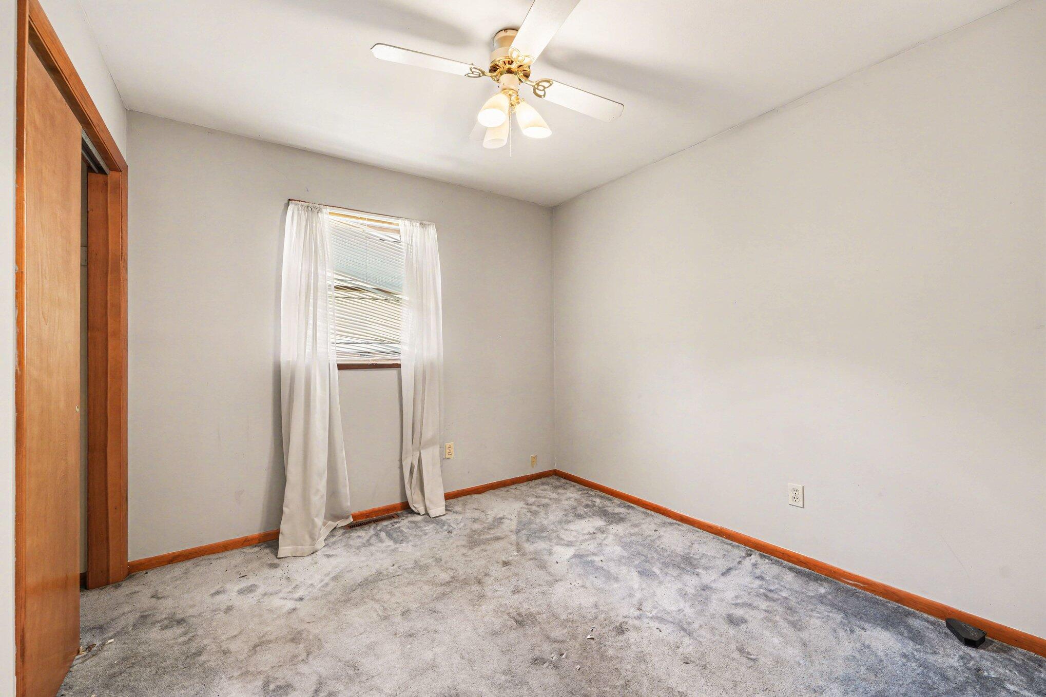 2423 Marshall Place Gary, IN 46404 - Photo 12 of 26 an empty room with a chandelier fan and windows