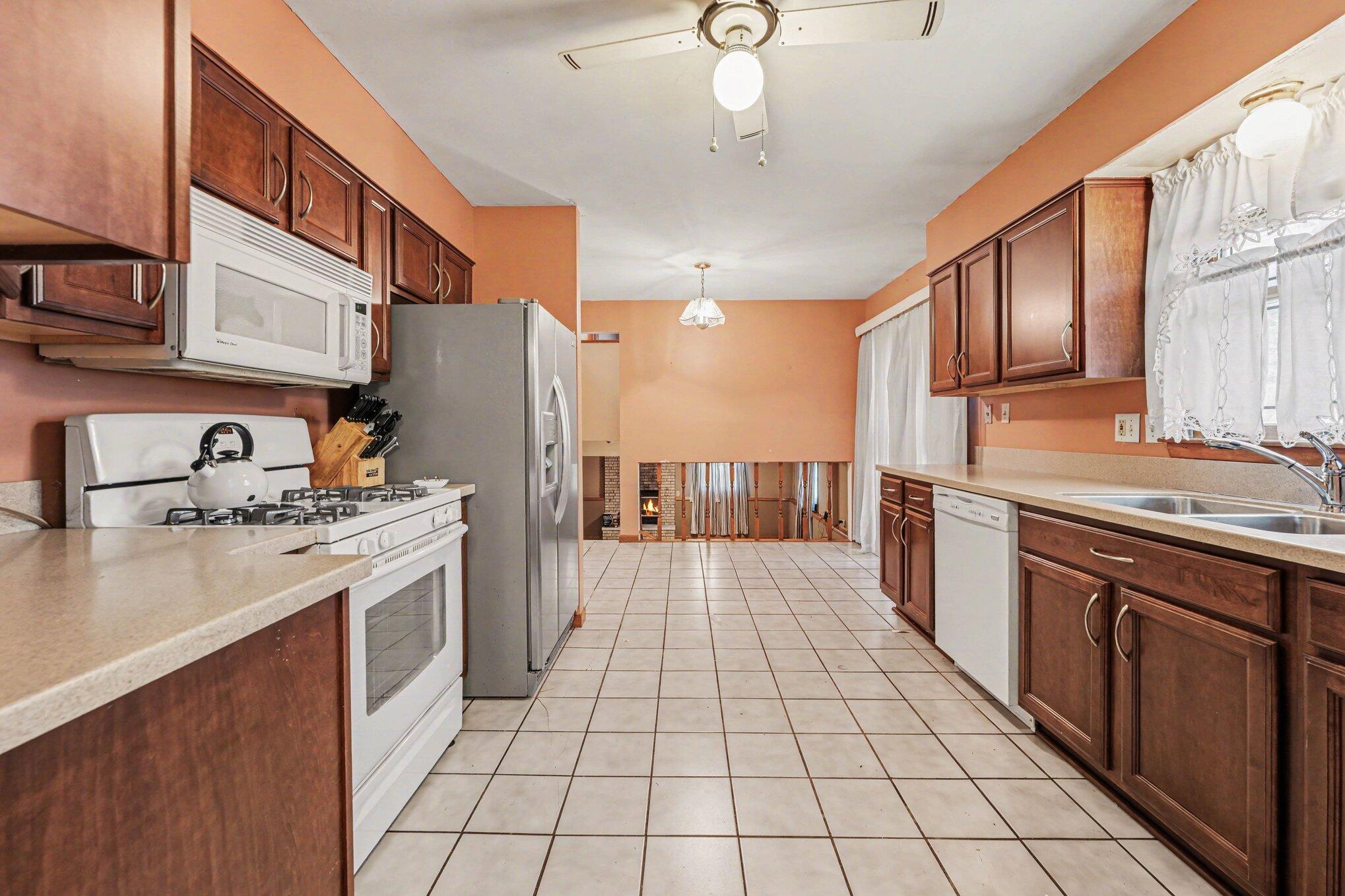 2423 Marshall Place Gary, IN 46404 - Photo 9 of 26 a large kitchen with stainless steel appliances granite countertop a stove top oven a sink dishwasher and a refrigerator