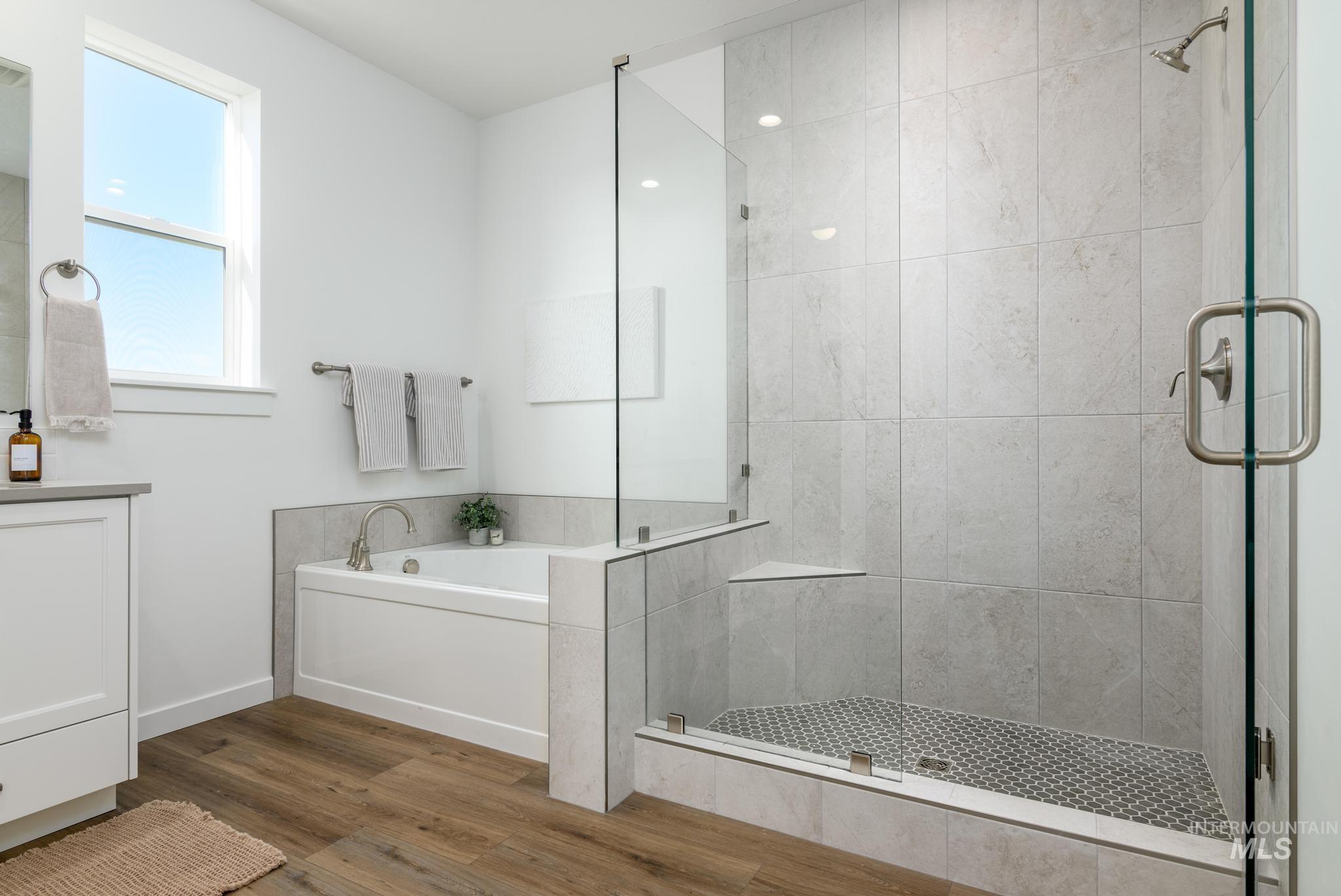 855 West Bay Street Middleton, ID 83644 - Photo 11 of 13 Full bath with a stall shower, a garden tub, vanity, and wood finished floors