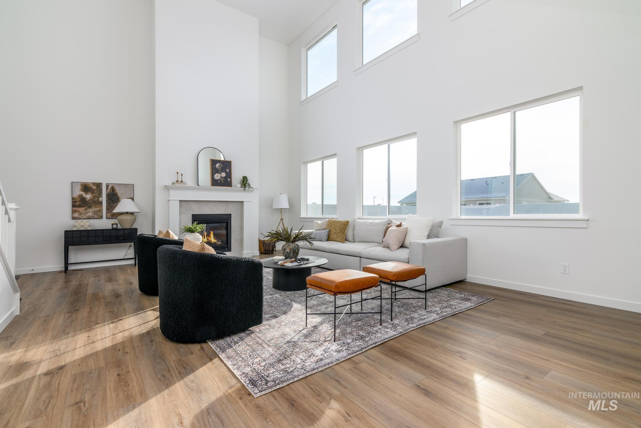 855 West Bay Street Middleton, ID 83644 - Photo 3 of 13 Living room featuring light wood-style floors, a tile fireplace, and a high ceiling