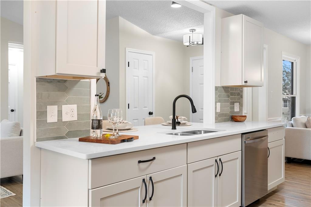 323 Lumpkin Street Winder, GA 30680 - Photo 11 of 30 a kitchen with sink and white cabinets
