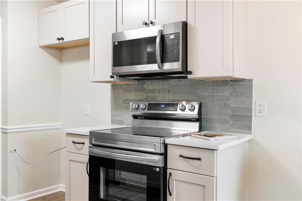 323 Lumpkin Street Winder, GA 30680 - Photo 13 of 30 a kitchen with a stove and a microwave