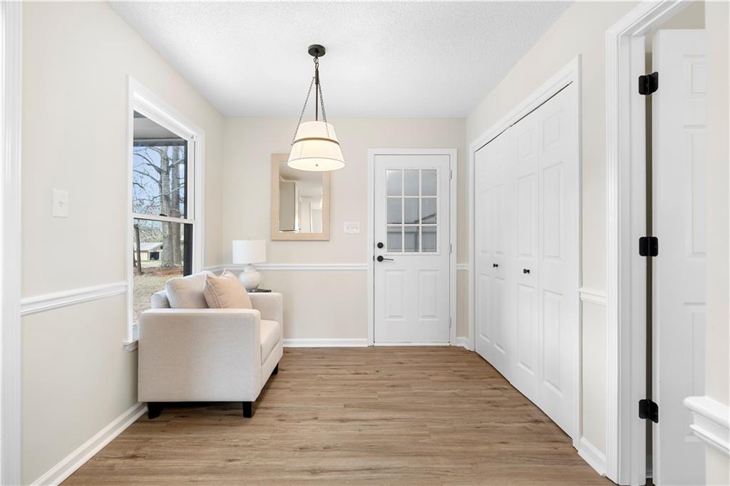 323 Lumpkin Street Winder, GA 30680 - Photo 15 of 30 a view of a livingroom with wooden floor and chandelier