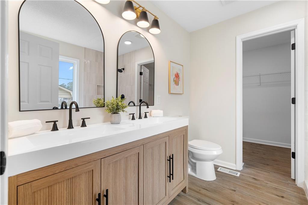 323 Lumpkin Street Winder, GA 30680 - Photo 18 of 30 a bathroom with a double vanity sink a toilet and a mirror