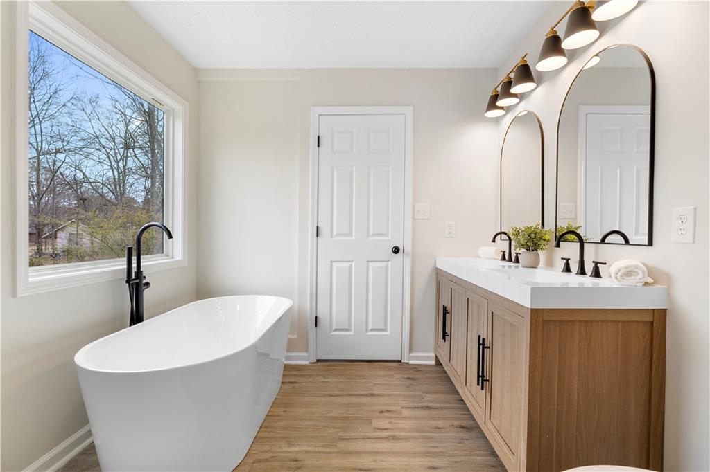 323 Lumpkin Street Winder, GA 30680 - Photo 20 of 30 a bathroom with a double vanity sink mirror and bathtub