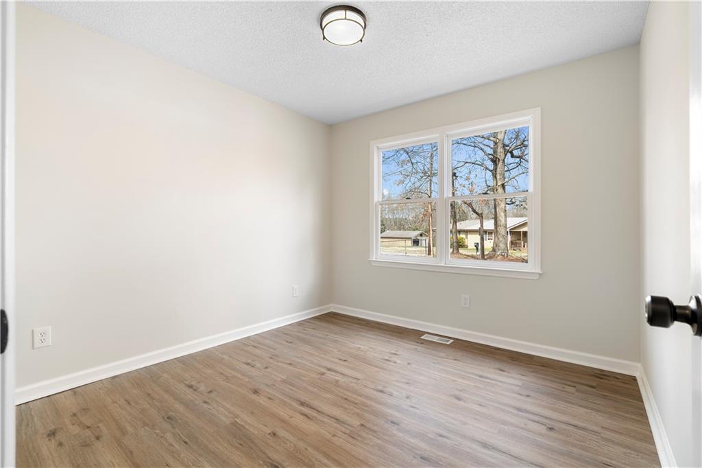 323 Lumpkin Street Winder, GA 30680 - Photo 21 of 30 an empty room with wooden floor and windows