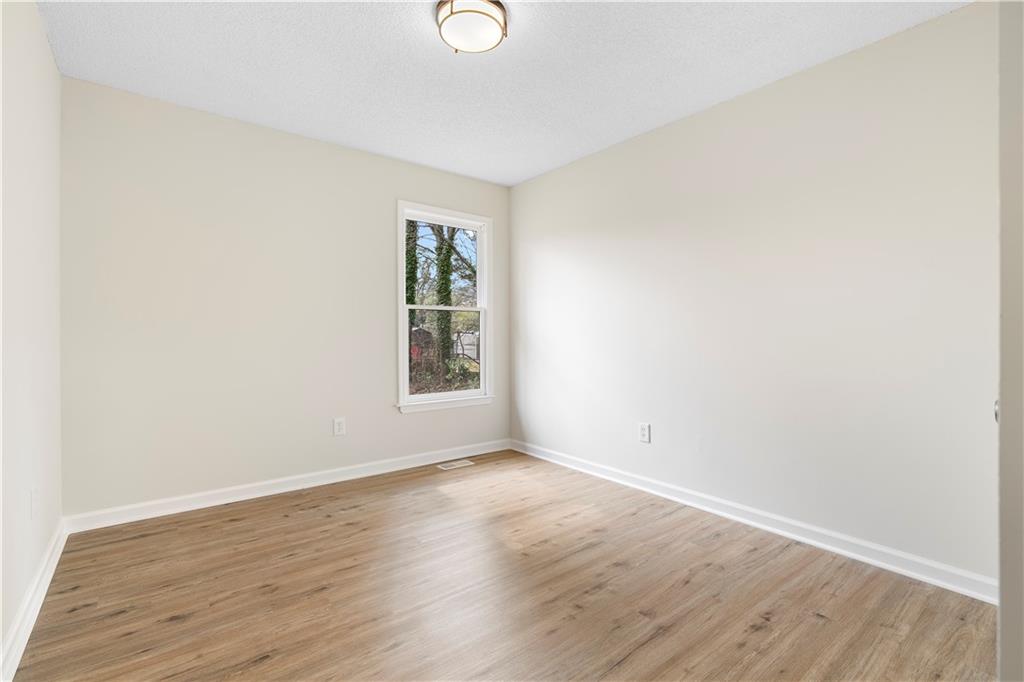 323 Lumpkin Street Winder, GA 30680 - Photo 22 of 30 an empty room with wooden floor and windows