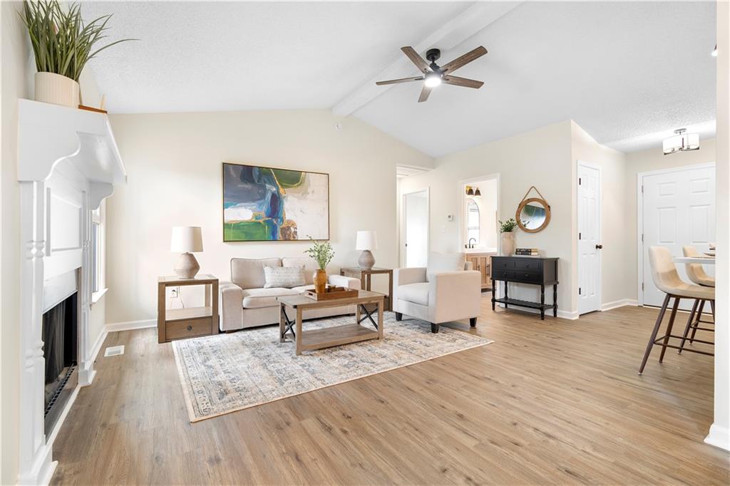 323 Lumpkin Street Winder, GA 30680 - Photo 6 of 30 a living room with furniture a fireplace and wooden floor