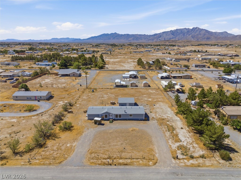 4331 Retread Road Pahrump, NV 89048 - Photo 3 of 31 An aerial perspective reveals a spacious lot with a single-story residence, framed by distant mountains.