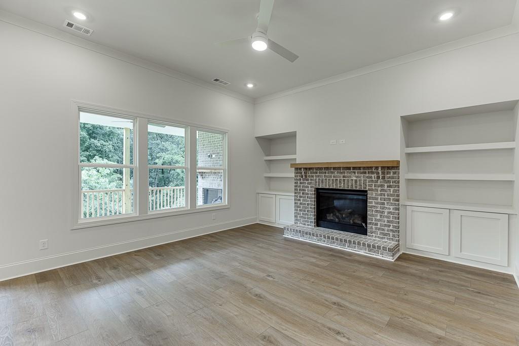 314 Level Creek Road Sugar Hill, GA 30518 - Photo 11 of 62 an empty room with wooden floor fireplace and windows