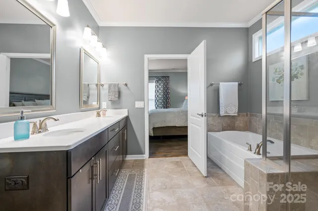 a bathroom with a tub double sink and mirror