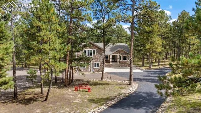a view of a white house next to a yard with a tree