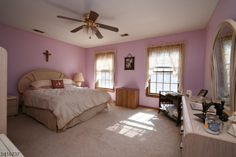 189 School House Road Oak Ridge, NJ 07438 - Photo 22 of 29 a bedroom with a bed and a chandelier