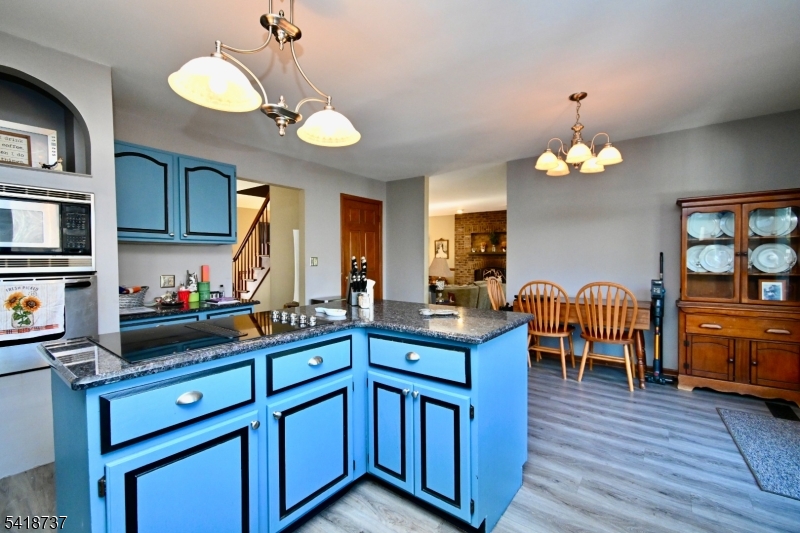 189 School House Road Oak Ridge, NJ 07438 - Photo 9 of 29 a kitchen that has cabinets a sink dishwasher and a dining table with wooden floor