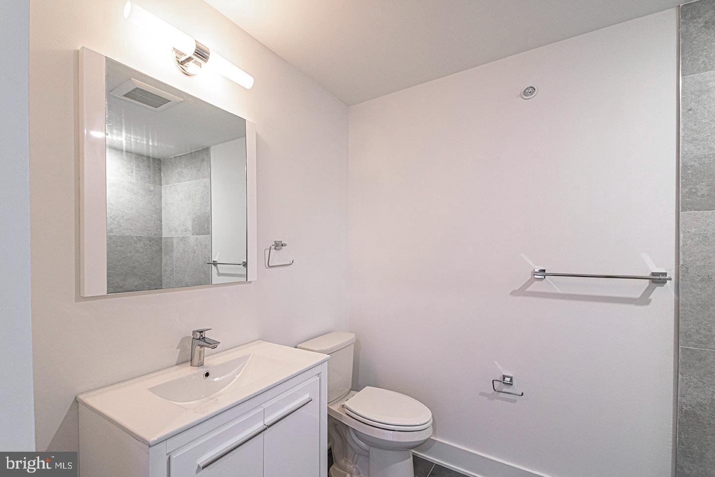 1245 Ridge Avenue, Unit 309 Philadelphia, PA 19123 - Photo 3 of 21 a bathroom with a sink mirror vanity and toilet
