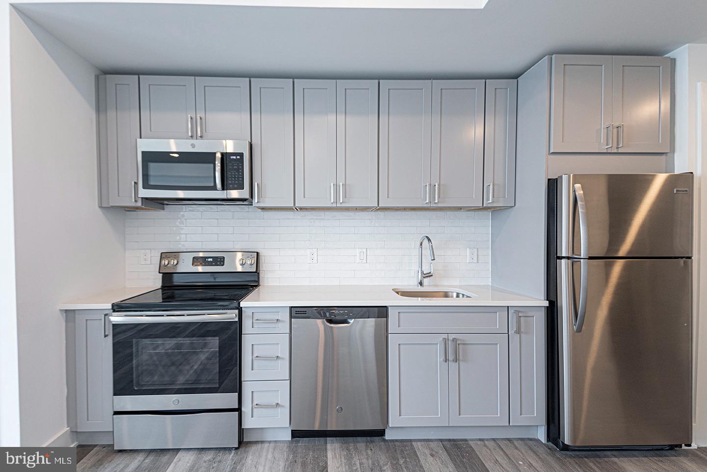1245 Ridge Avenue, Unit 309 Philadelphia, PA 19123 - Photo 8 of 21 a kitchen with cabinets stainless steel appliances and wooden floor