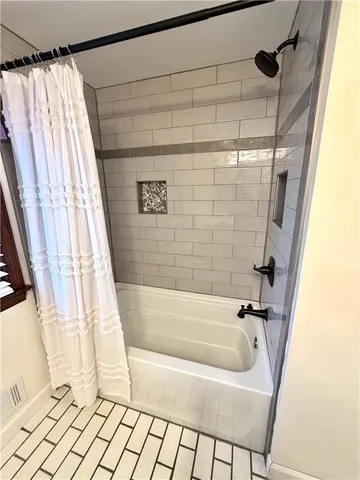 a bathroom with a bathtub and shower