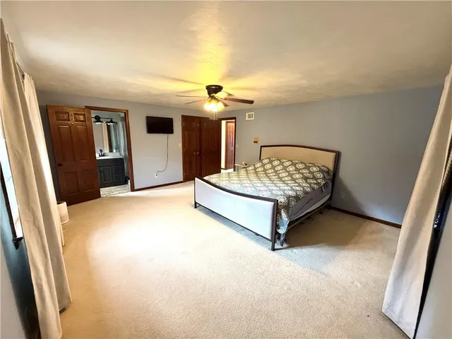 a spacious bedroom with a bed and a chandelier