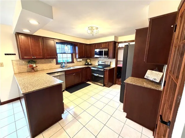 a kitchen with stainless steel appliances a stove refrigerator sink and cabinets