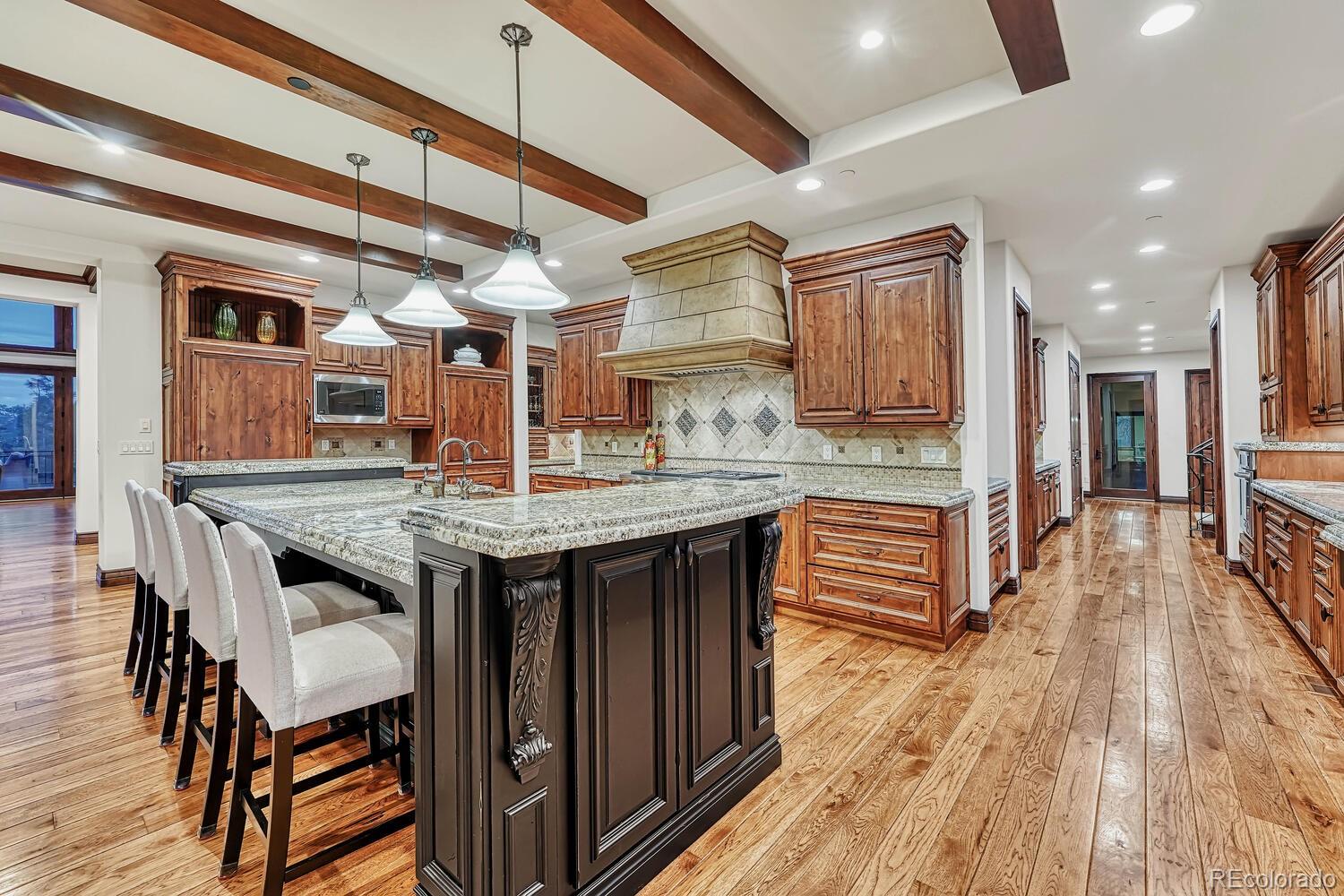 7959 Forest Keep Circle Parker, CO 80134 - Photo 13 of 40 a kitchen with granite countertop a table chairs a sink dishwasher refrigerator and wooden cabinets