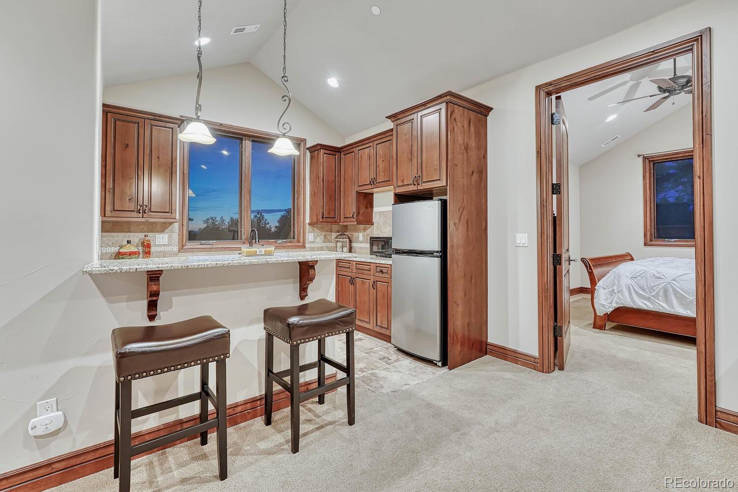 7959 Forest Keep Circle Parker, CO 80134 - Photo 24 of 40 a kitchen with stainless steel appliances kitchen island granite countertop a refrigerator and microwave