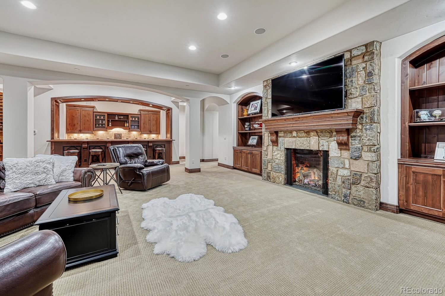 7959 Forest Keep Circle Parker, CO 80134 - Photo 26 of 40 a living room with furniture a flat screen tv and a fireplace