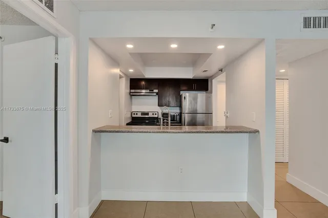 a kitchen with stainless steel appliances a refrigerator and a stove top oven