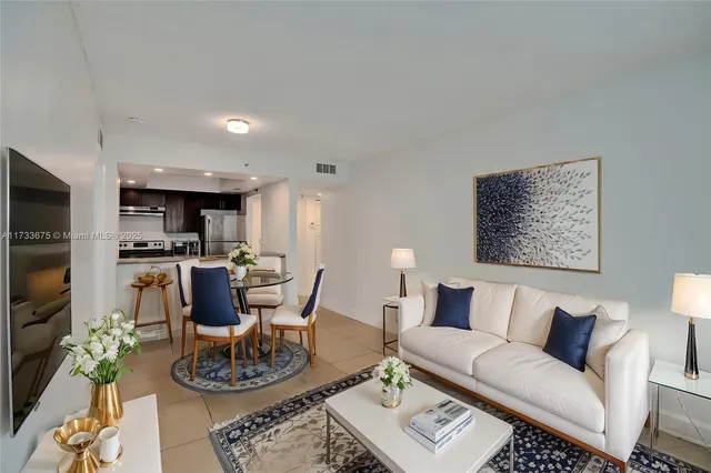 a living room with furniture and kitchen view
