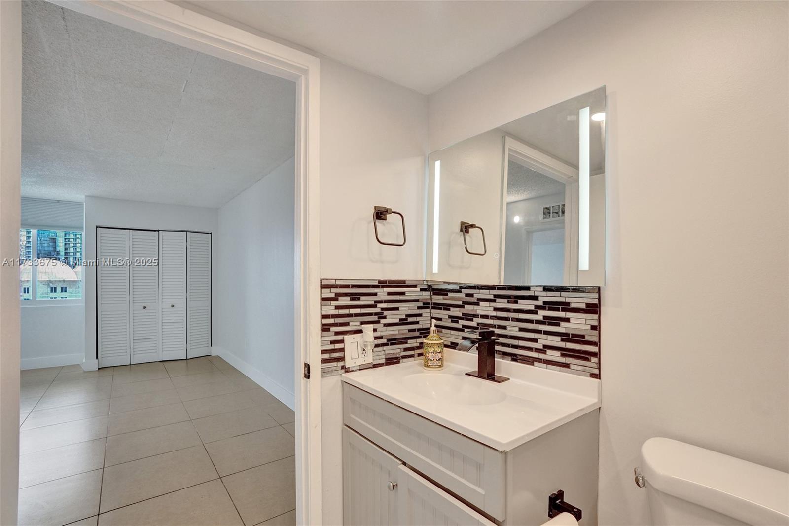 850 North Miami Avenue, Unit W1810 Miami, FL 33136 - Photo 6 of 31 a bathroom with a sink and a mirror