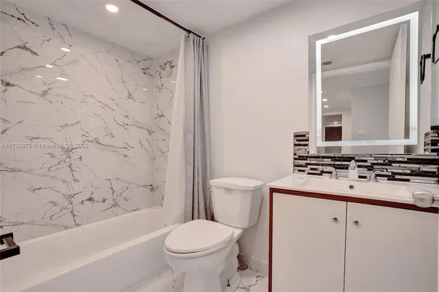 a bathroom with a sink toilet vanity and shower