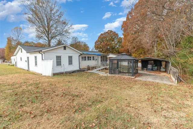 a view of a house with a large tree and a yard