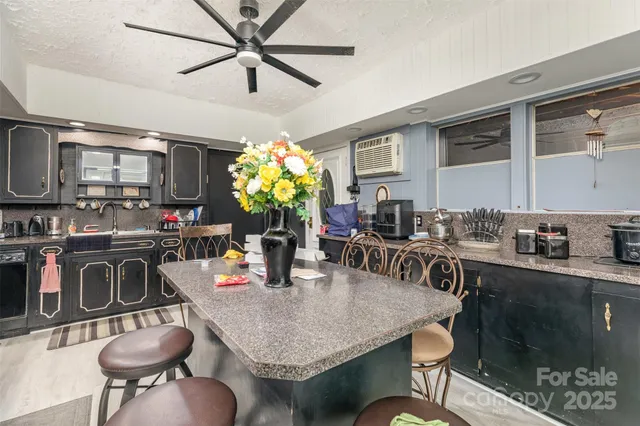 a kitchen with stainless steel appliances granite countertop a stove a sink dishwasher a dining table and chairs with wooden floor