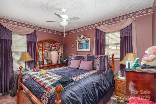 a bedroom with a bed a flat screen tv and a window