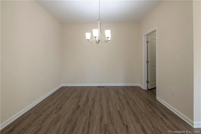 a view of a room with wooden floor chandelier and closet