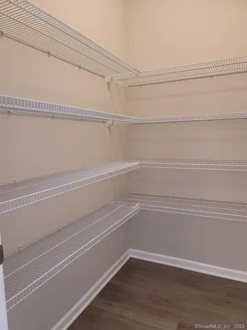 a view of a closet with wooden floor